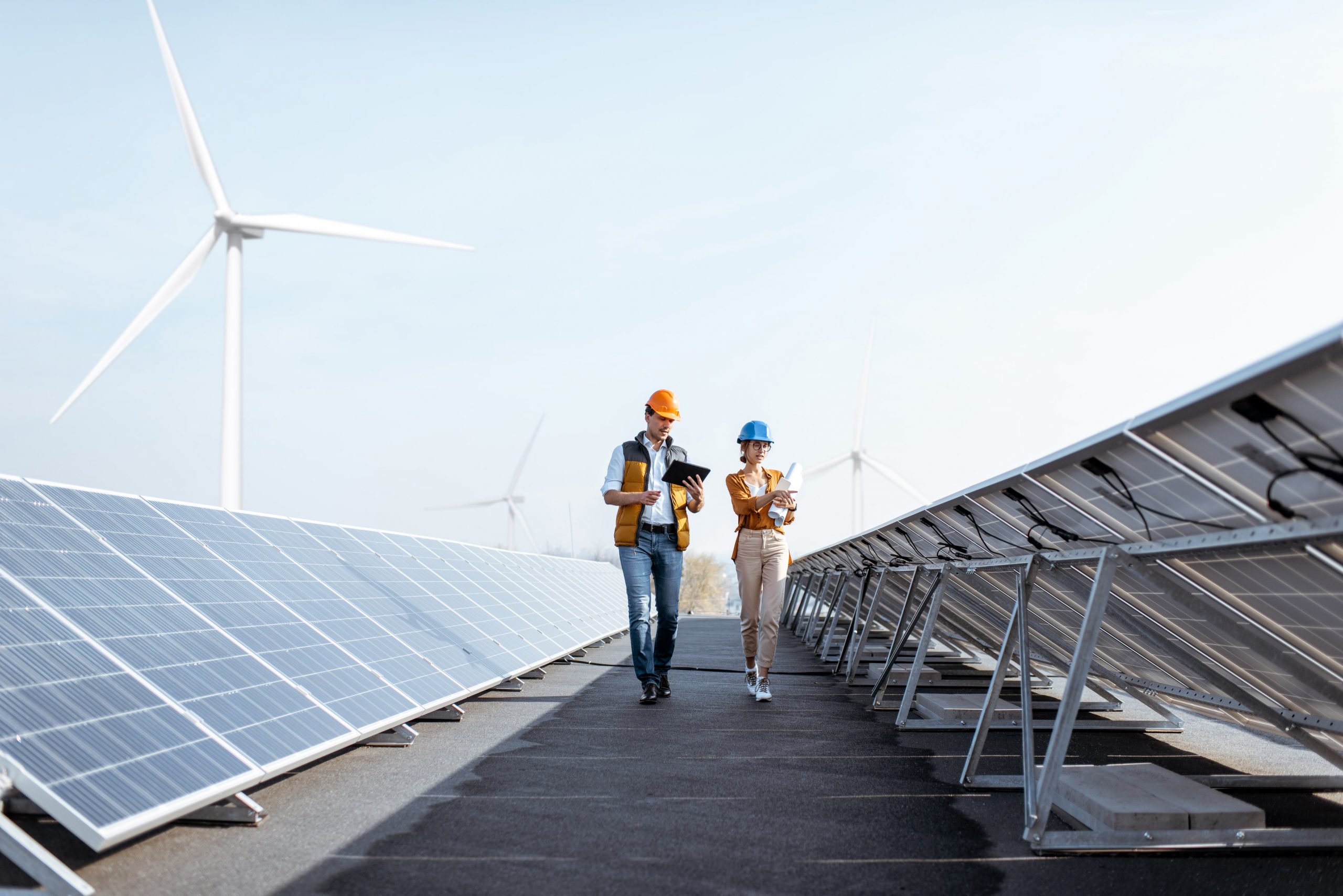 two workers walking between solar panels