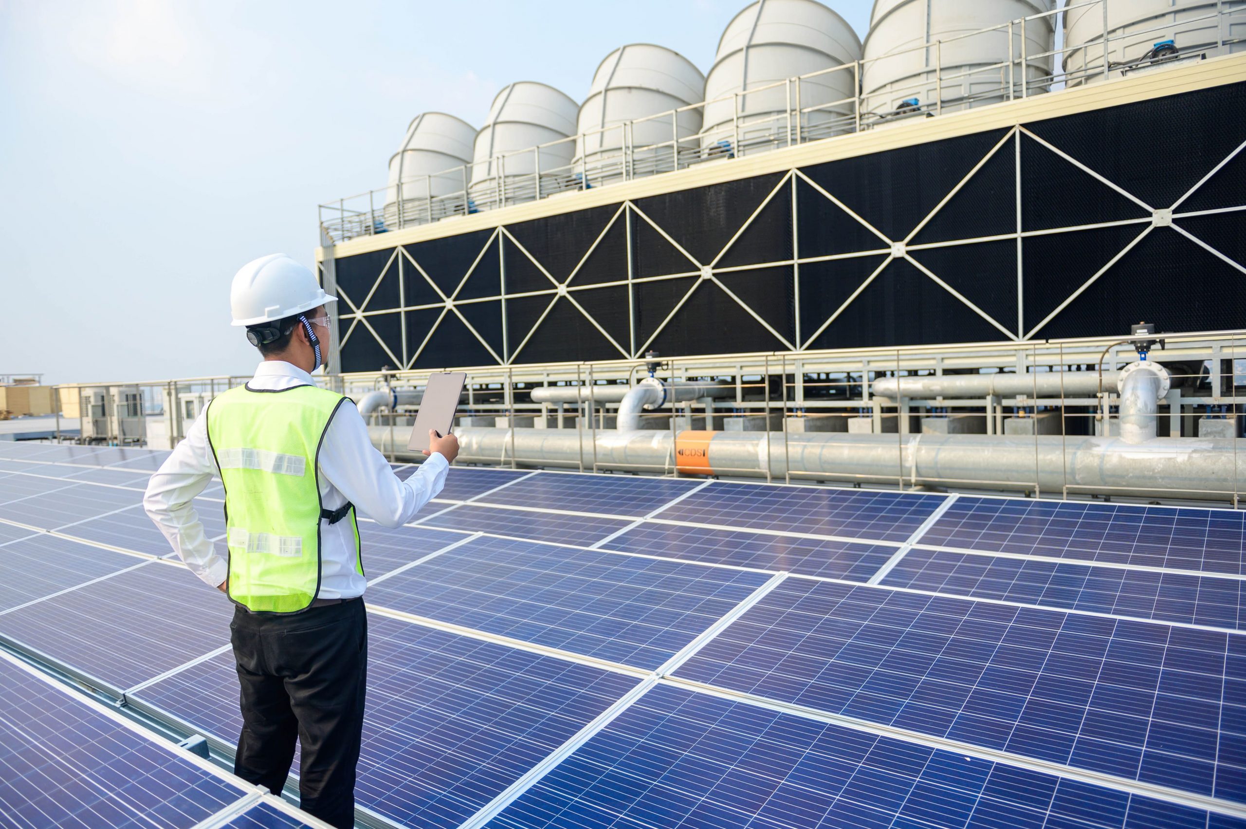 man standing between solar panels on a roof