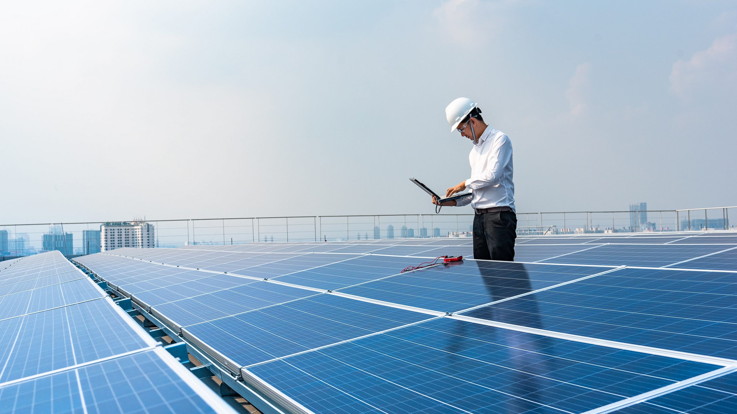 man standing on a roof with a laptop