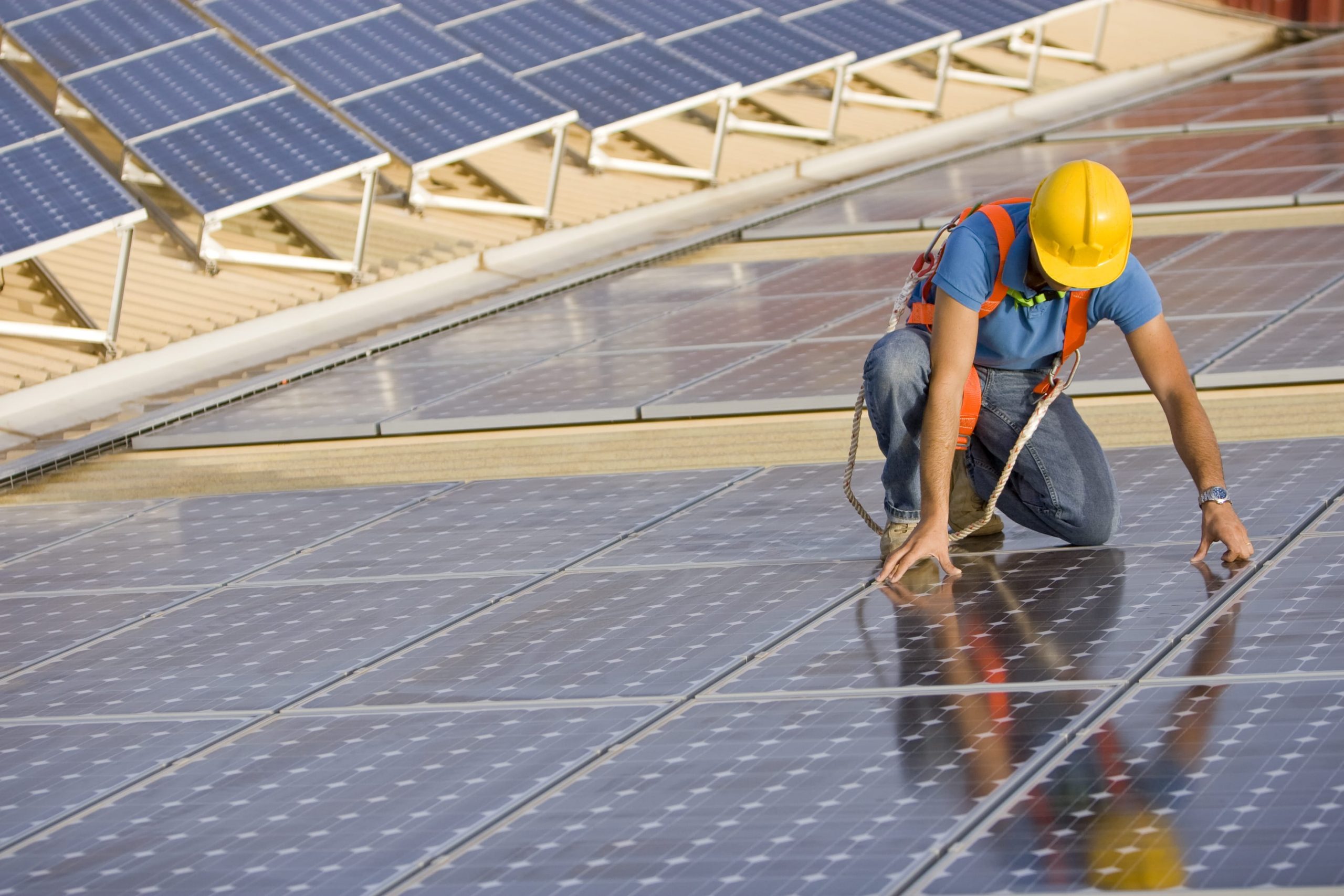 man in hardhat installing solar panels