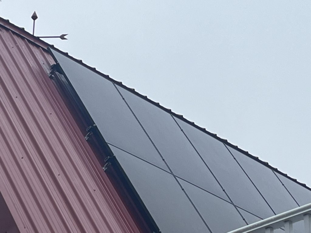 Solar modules gather energy atop the metal roof of a barn converted to a home.