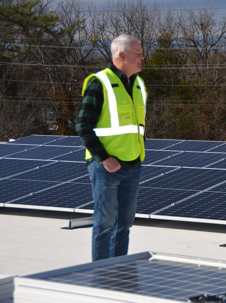 Business owner looking at new solar installation on roof.