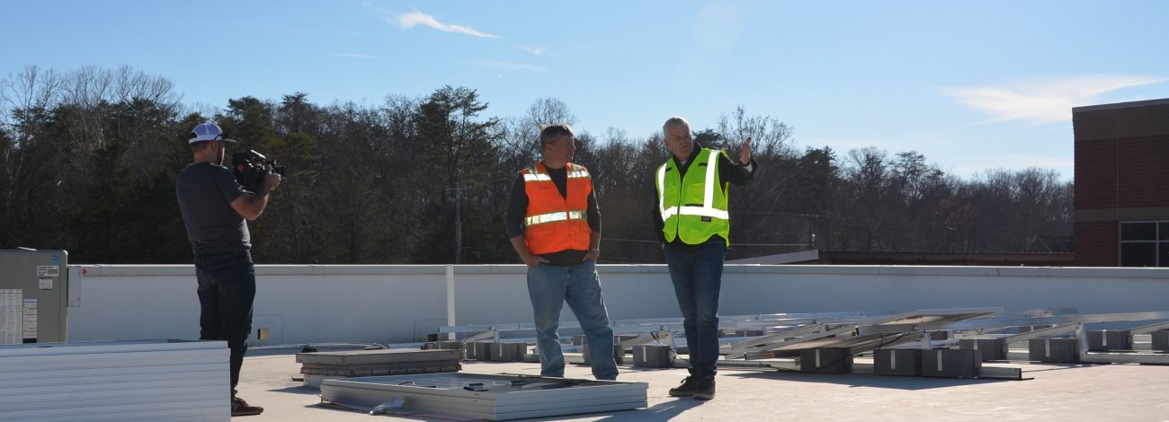 Business owners oversees solar installation on his office building.