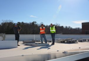 Business owners oversees solar installation on his office building.