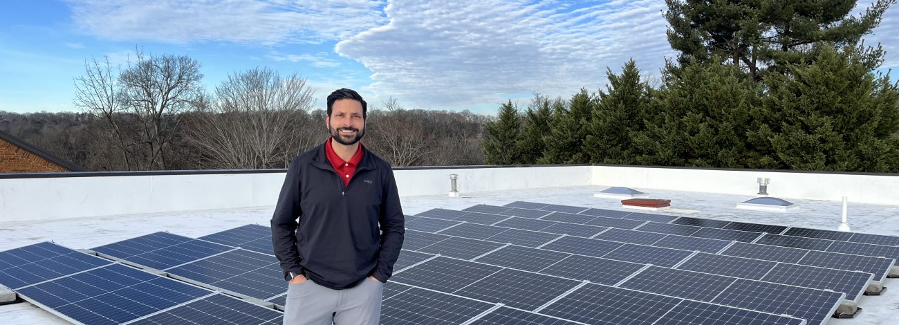 Business owner atop roof with newly installed solar.