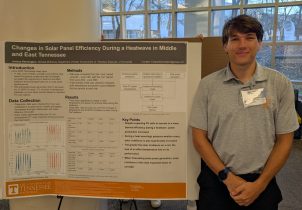 student with research poster on solar energy